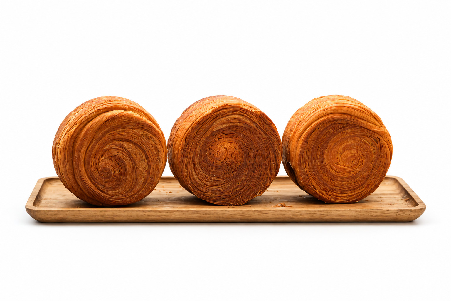 Three round croissants on a wooden board